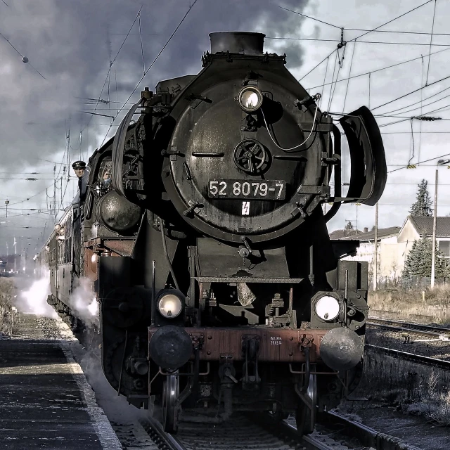 a train traveling down train tracks next to a train station, by Kristian Zahrtmann, pixabay contest winner, art nouveau, thick pigmented smoke, good looking face, set in ww2 germany, big engine