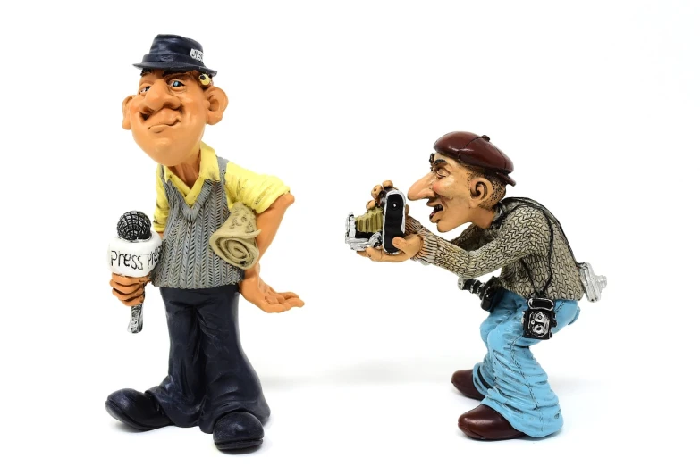 a couple of figurines of men standing next to each other, a picture, by senior artist, trending on pixabay, figuration libre, cameras, screaming at the camera, don ramon, journalistic photograph