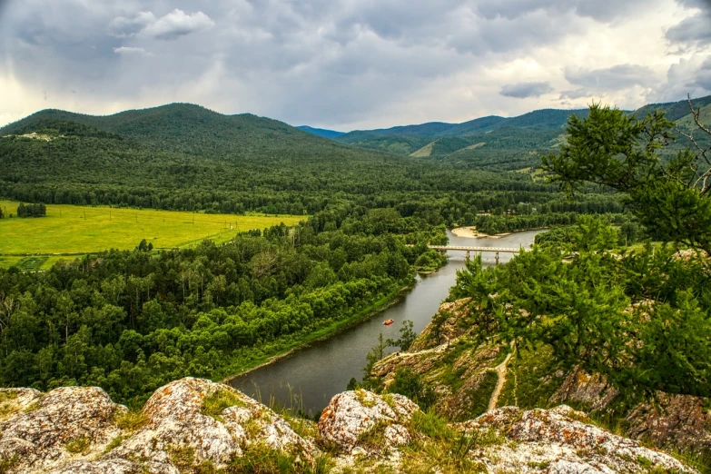 a river running through a lush green valley, a portrait, by Svetlin Velinov, shutterstock, russian landscape, kashin, in the distance is a rocky hill, very known photo