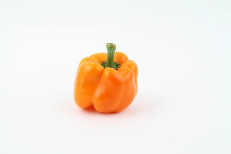a small orange pepper on a white surface, a picture, renaissance, 5 5 mm photo