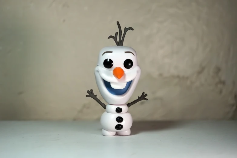 a close up of a toy snowman on a table, a picture, inspired by Olaf Rude, pexels, minimalism, smiling and dancing, funko pop, face shown, elsa