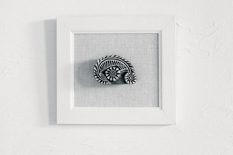 a black and white picture of a shell in a white frame, featured on behance, folk art, hindu ornaments, miniature product photo, wood block pirnt, on a pale background