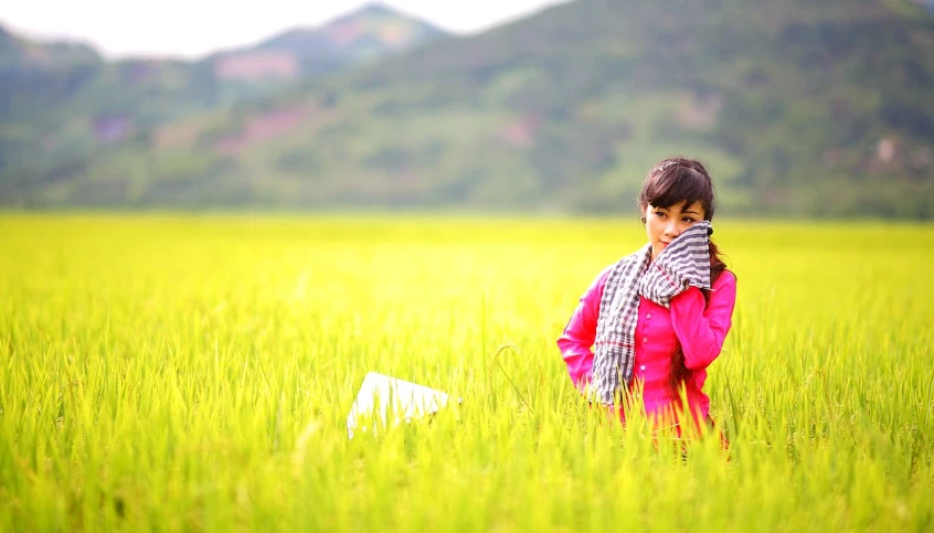 a little girl standing in a field with a kite, by Ju Lian, flickr, beautiful young korean woman, malaysia with a paddy field, ! movie scene, wearing hay coat