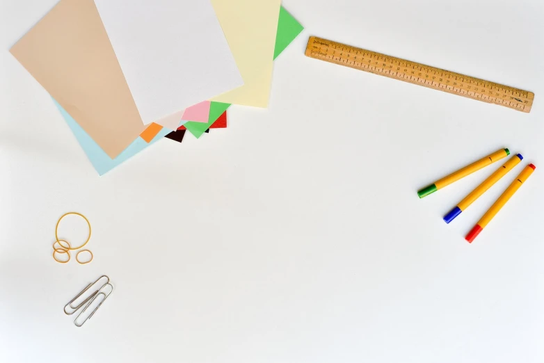 a group of office supplies sitting on top of a white table, a minimalist painting, background image, colorful ideas, paper border, overview