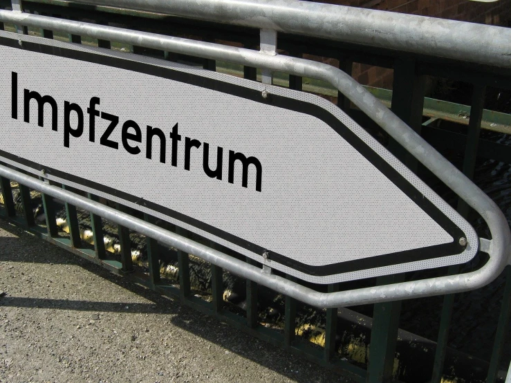 a close up of a street sign near a fence, by Fritz Puempin, flickr, panfuturism, white font on black canvas, gateway to futurisma, zeppelin dock, petting zoo
