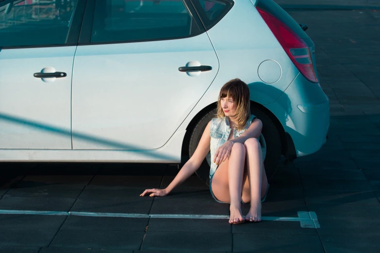 a woman sitting on the ground next to a white car, a stock photo, inspired by Elsa Bleda, shutterstock, photorealism, imogen poots paladin, clemens ascher, evening sun, 7 0 mm portrait