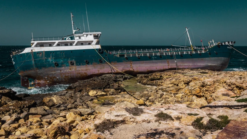 a boat sitting on top of a rocky beach, a portrait, by Richard Carline, auto-destructive art, dredged seabed, cape, water surrounds the ship, taken with a leica camera