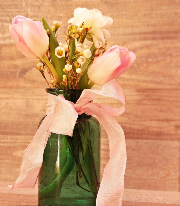 a green vase filled with pink and white flowers, 513435456k film, ribbon, roses and tulips, glass jar