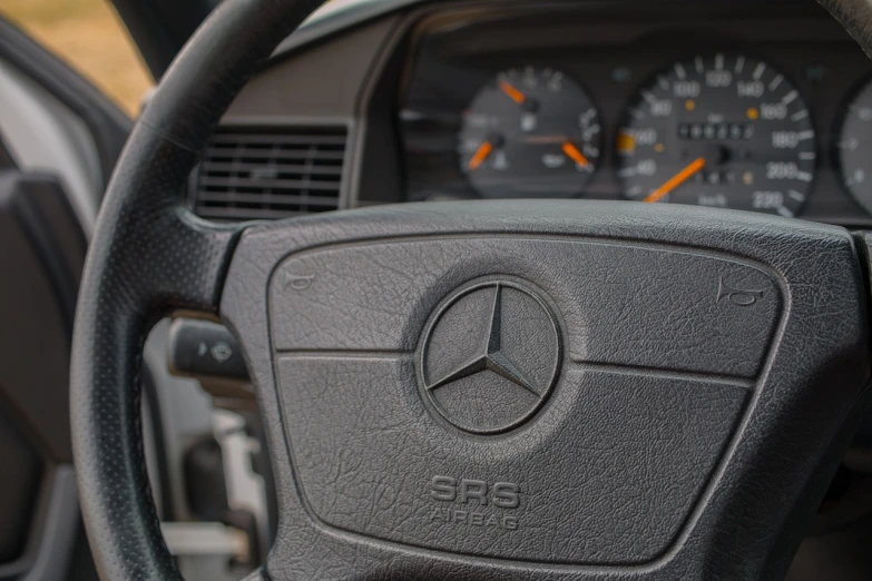 a close up of a steering wheel on a car, a portrait, photorealism, 80s photo, mercedez benz, 8 k hyper detailed image, high details photo