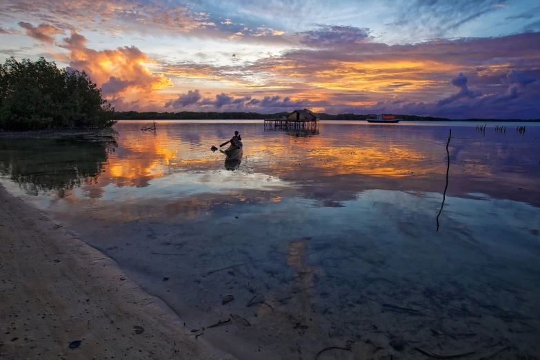 a person in a boat on a body of water, by Niklaus Manuel, shutterstock, hurufiyya, sunset with cloudy skies, lagoon, very clear picture, awarded winning photo