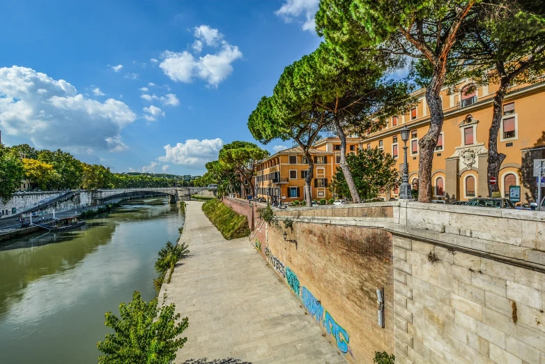 a river running through a city next to tall buildings, a photo, by Alessandro Allori, shutterstock, graffiti, ancient rome, river and trees and hills, railing along the canal, stock photo