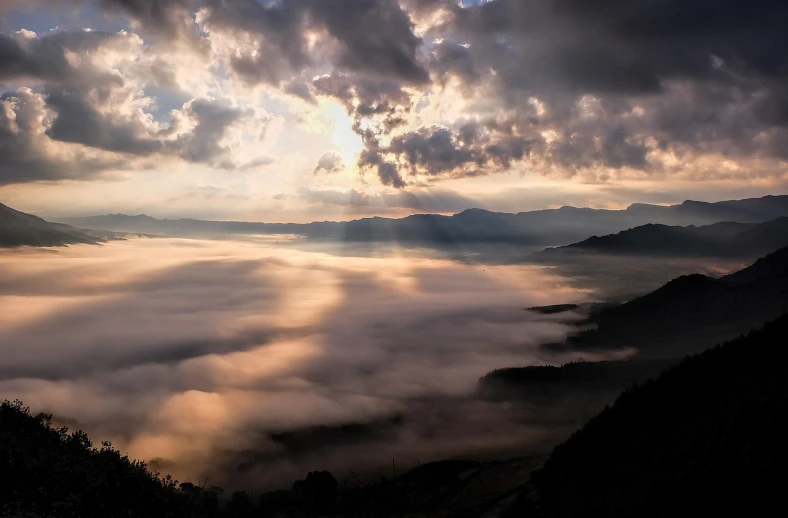 the sun shines through the clouds above the mountains, by Shi Rui, blanket of fog, god rays!!!, wide wide shot, cotton clouds