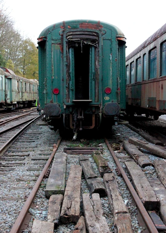 a green train sitting on top of a train track, a portrait, flickr, decaying, rear view, vintage - w 1 0 2 4, bottom shot