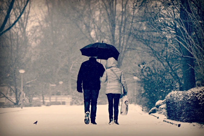 two people walking in the snow with an umbrella, a picture, pexels, romanticism, colorkey scene, lovely couple, watch photo