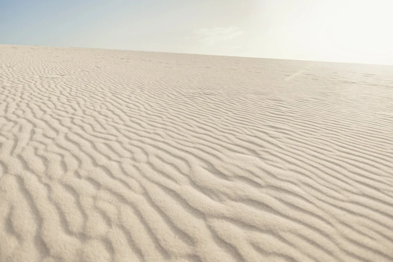 a man riding a snowboard down a snow covered slope, a picture, unsplash, minimalism, somewhere in sands of the desert, rippled white landscape, an expansive grassy plain, quixel megascans