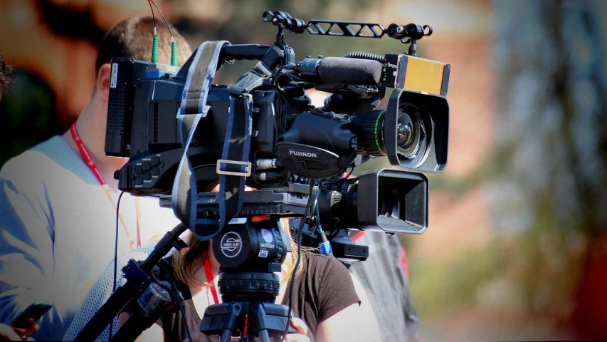 a close up of a camera on a tripod, televisions, pictured from the shoulders up, big production, manifestation