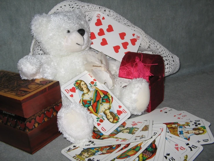 a white teddy bear sitting next to a pile of playing cards, by Susan Heidi, flickr, ebay photo, several hearts, presents, german