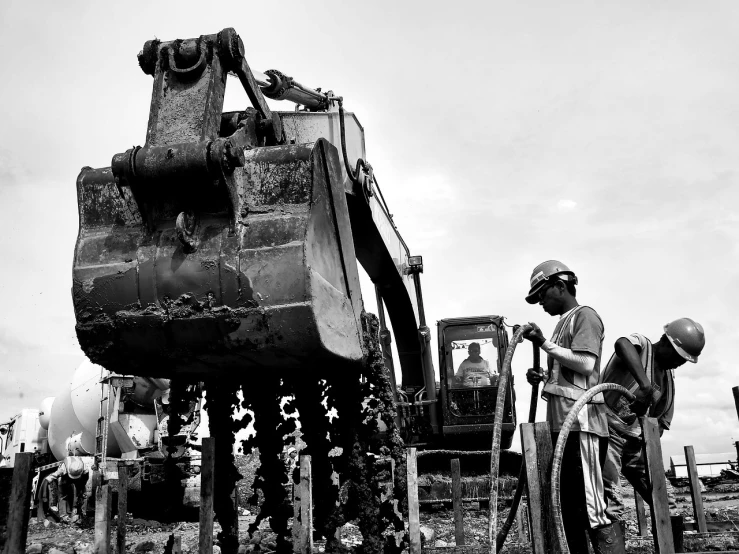 a couple of men that are standing in the dirt, by Robert Jacobsen, process art, heavy machinery, malaysian, 4k greyscale hd photography, slice of life