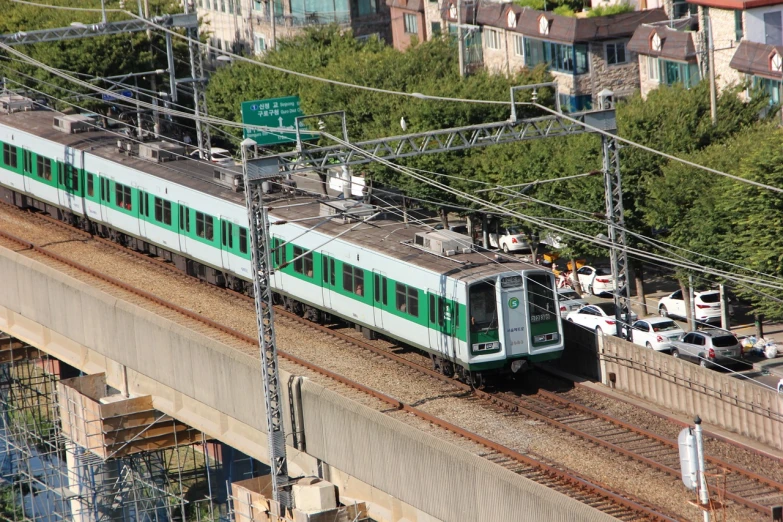 a large long train on a steel track, flickr, sōsaku hanga, charging through city, a green, dsrl photo, image