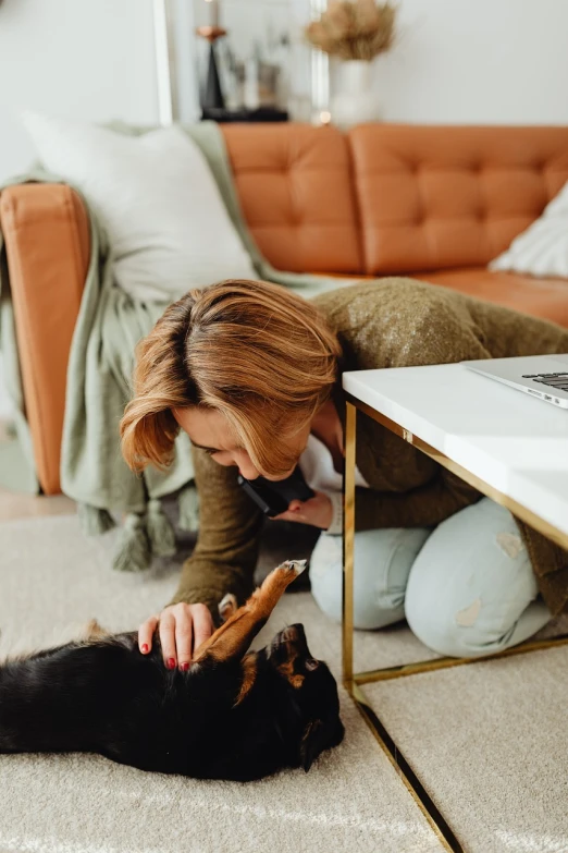 a woman playing with a dog on the floor, a picture, by Emma Andijewska, pexels contest winner, istockphoto, spying discretly, digging, calmly conversing 8k