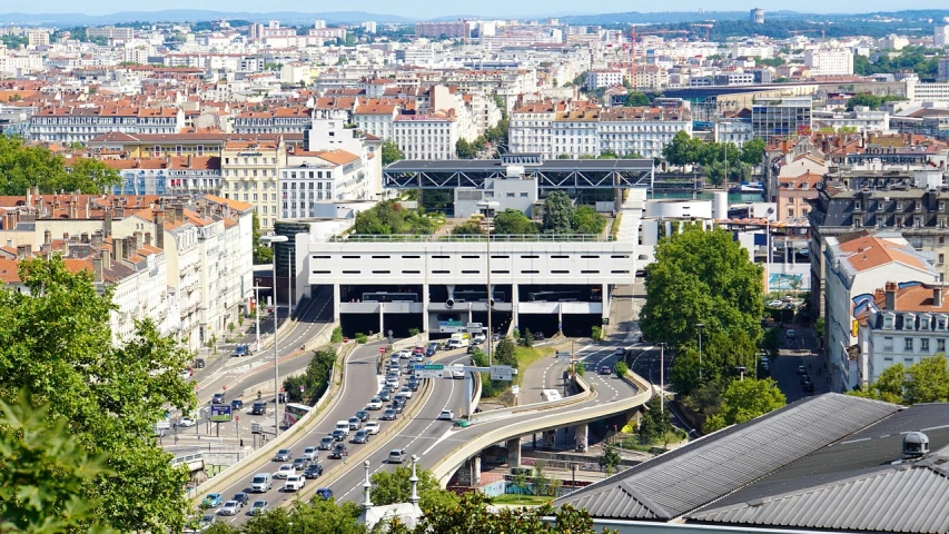 a view of a city from the top of a hill, by Oskar Lüthy, shutterstock, train station in summer, arkane lyon, traffic, gateway