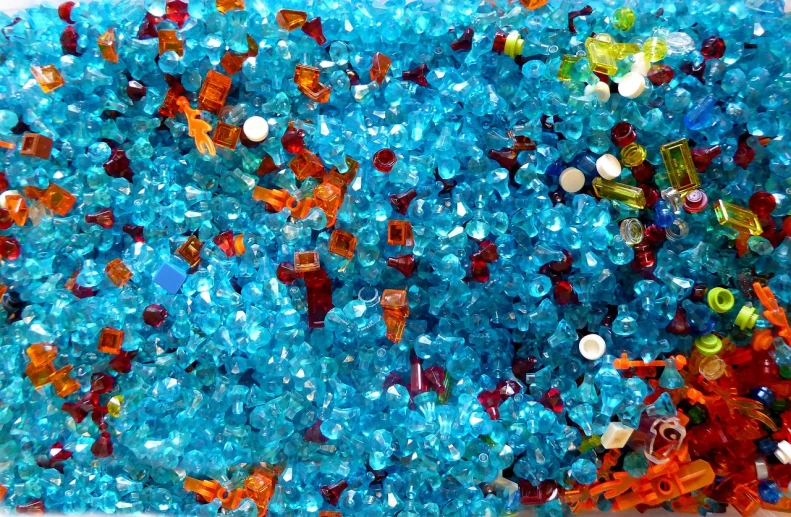 a tray filled with lots of different colored beads, inspired by Howardena Pindell, crystal cubism, abstract design. blue, underwater crystals, street life, glass texture