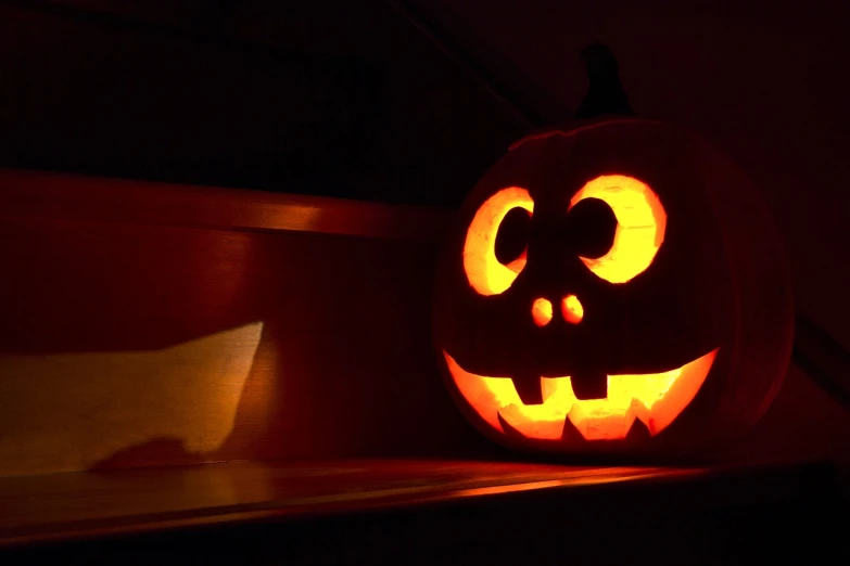 a jack o lantern lit up in the dark, by Stefan Gierowski, closeup of an adorable, backlit glow, lit from the side, noon