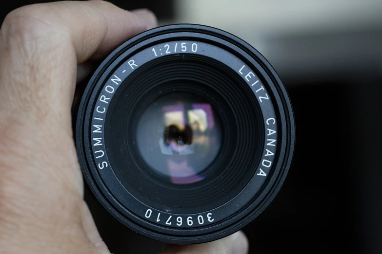 a close up of a person holding a camera lens, by Jan Rustem, reddit, photorealism, leica summicron-t 23 mm f/2, flickr explore 5 0 mm, by greg rutkowski, very short depth of field