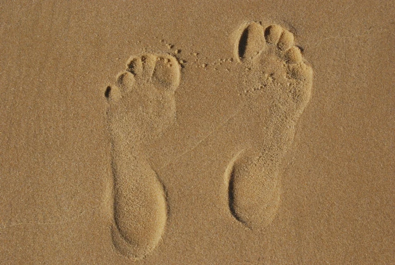 two footprints in the sand of a beach, by Bernardo Daddi, symbolism, very very well detailed image, portait photo