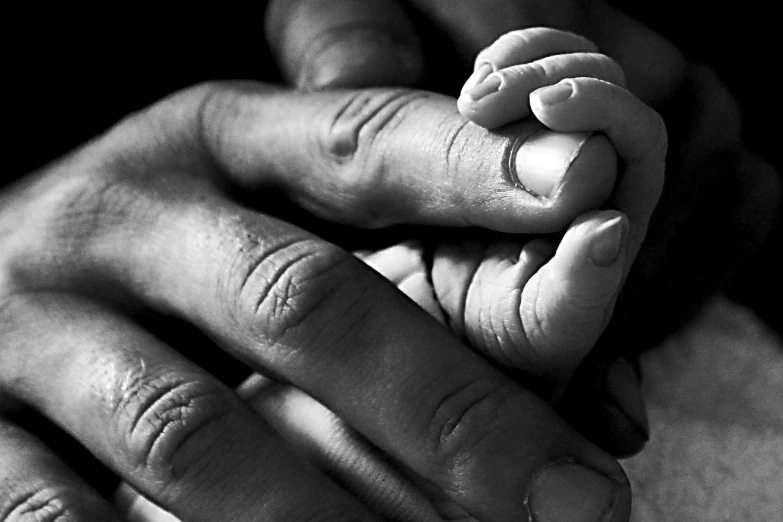 a close up of a person holding a baby's hand, a black and white photo, by Arthur Sarkissian, symbolism, enhanced photo, dsrl photo, warmth, today's featured photograph