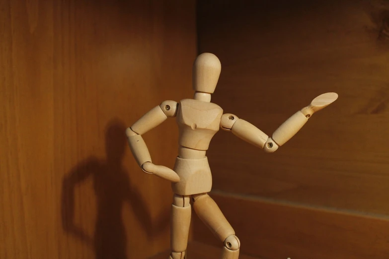 a wooden mannequin standing in front of a wooden wall, figuration libre, dancing a jig, action figurine toy, [ closeup ]!!, standing in class