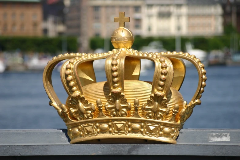 a golden crown sitting on top of a metal fence, inspired by karlkka, baroque, 1 5 6 6, stockholm, ruler of everything, royalcore