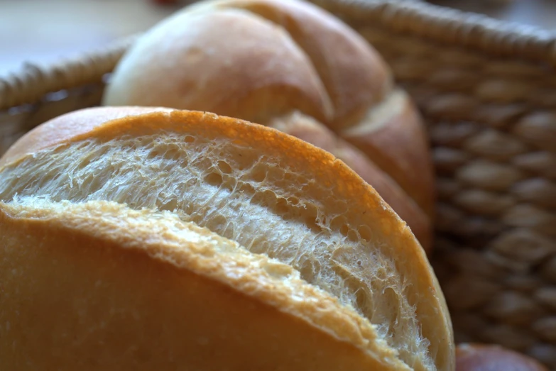a basket of bread sitting on top of a table, by Yasushi Sugiyama, flickr, high detailed close up of, soft internal light, brazilian, sliced bread in slots