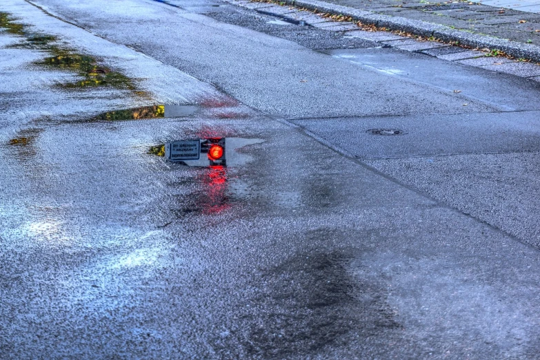 a red traffic light sitting on the side of a road, a photo, by Raymond Normand, water on the floor, hdr photo, unexpected windfall, phone photo