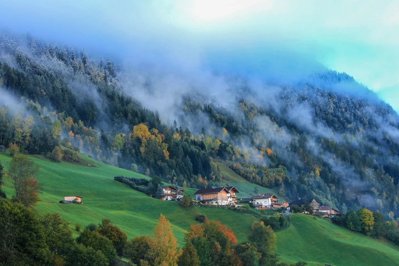 a herd of sheep grazing on top of a lush green hillside, a tilt shift photo, by Franz Hegi, flickr, renaissance, log cabin beneath the alps, blankets of fog pockets, autumn colors, realistic photo of a town