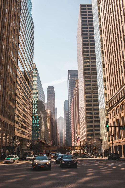 a city street filled with lots of tall buildings, by Andrew Domachowski, pexels contest winner, illinois, stock photo, wide establishing shot, lots of sunlight