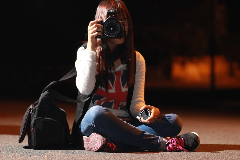 a woman sitting on the ground taking a picture with a camera, a picture, (((low light))), flickr photography, photo of the girl, taken with my nikon d 3