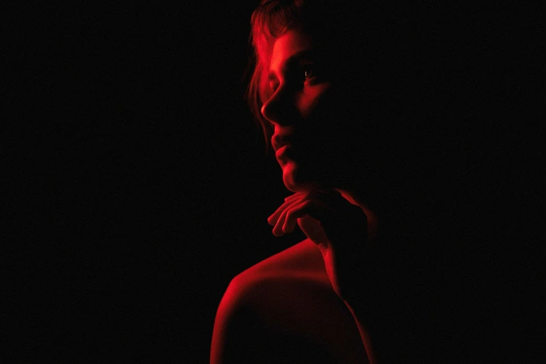 a close up of a person in a dark room, by João Artur da Silva, vibrant red 8k, female image in shadow, photo of the girl, gaspar noe