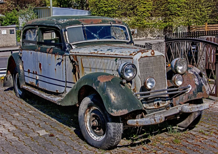 an old car is parked on the side of the road, by Hans Fischer, trending on pixabay, photorealism, under repairs, front side full, panzer, highly ornate
