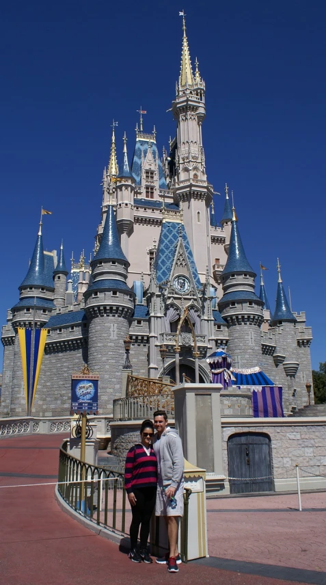 a man and a woman standing in front of a castle, by Walt Disney, flickr, clear blue skies, !!highly detailed!!, majestic spires, 2 0 1 0 photo