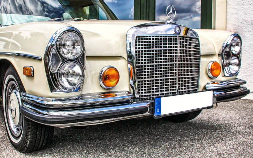 a classic car parked in front of a building, by Thomas Häfner, trending on pixabay, photorealism, with a white muzzle, mercedez benz, headlights, 7 0 s photo