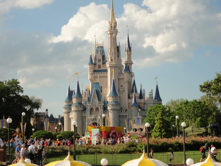 a group of people standing in front of a castle, by Walt Disney, flickr, visible from afar!!, picnic, sunny day time, very detailed picture