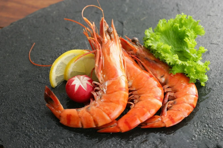 a bunch of shrimp sitting on top of a black plate, a portrait, by Richard Carline, pixabay, shin hanga, pointè pose, 3 - piece, soft - warm, product introduction photo