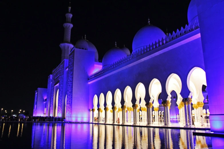 a large white building lit up at night, by Sheikh Hamdullah, pixabay, hurufiyya, blue and purple colour scheme, cybermosque interior, festivals, header