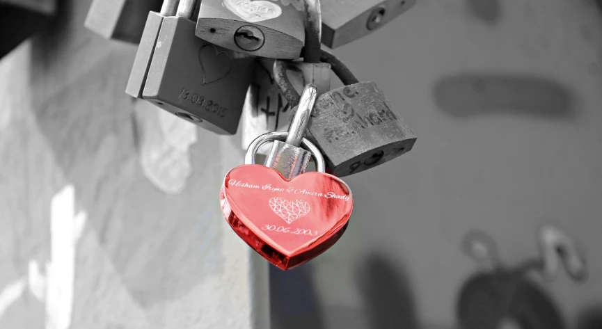 a heart shaped padlock attached to a wall, a photo, silver white gold red details, black and white color photograph, engraved, dlsr photo
