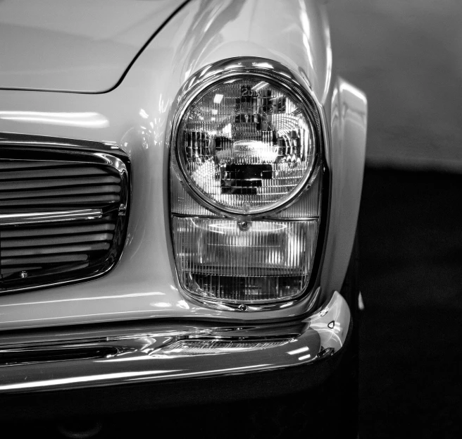 a black and white photo of a classic car, by Etienne Delessert, pexels contest winner, photorealism, bright headlights, mercedes, miura kentaro style, detail face