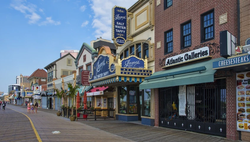 the boardwalk is lined with shops and restaurants, a photo, by Jeffrey Smith, shutterstock, renaissance, new jersey, seen from outside, the movie, majestic”