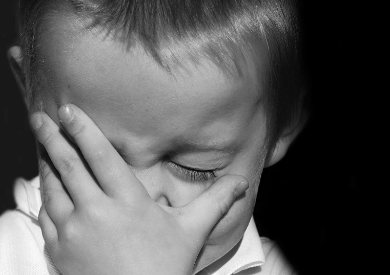 a young boy covers his face with his hands, a black and white photo, pixabay, crying softly and humbly, 4yr old, closeup photo, slide show