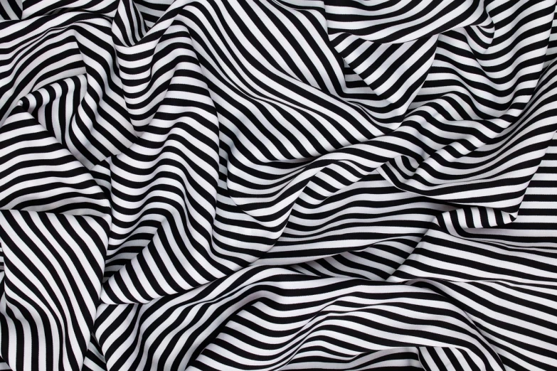 a close up of a black and white striped fabric, an abstract drawing, inspired by Bridget Riley, shutterstock, flowing silk sheets, best on adobe stock, folded, hyper realistic”