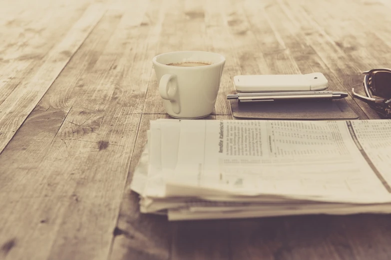 a cup of coffee sitting on top of a wooden table, a picture, private press, newspaper article, stacked image, gazeta, empty